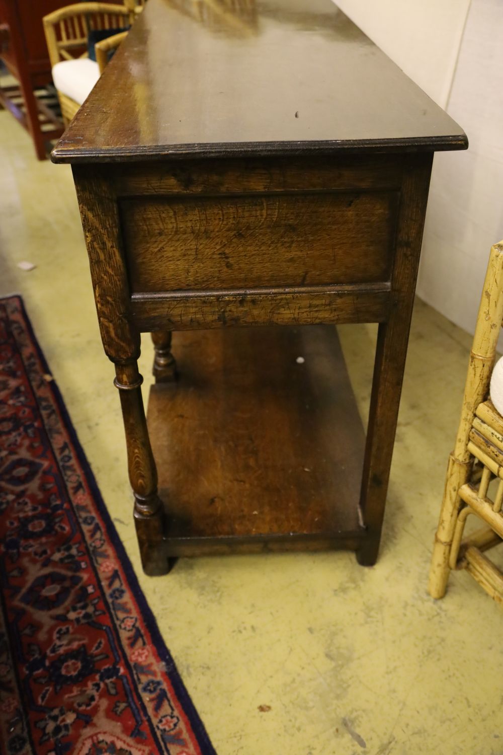 A George III style oak dresser base, fitted three drawers and undertier, width 138cm, depth 46cm, height 76cm